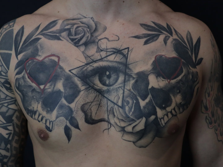 skull, roses and eye chest tattoo in black and grey